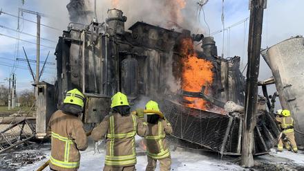 Ukrainische Feuerwehrleute löschen getroffene Stromnetz-Infrastruktur in der Region Riwne.