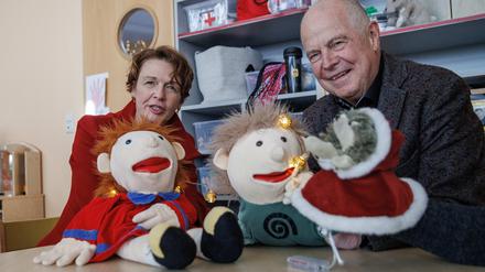 Elke Büdenbender, Ehefrau des Bundespräsidenten, und Matthias Bräutigam (r), Sprachpate, spielen mit Handpuppen bei dem Besuch einer Kita in einem Kinderzimmer.