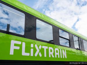 Ein Großraumwagen des Unternehmens Flixtrain steht in Aachen auf dem Gleis.