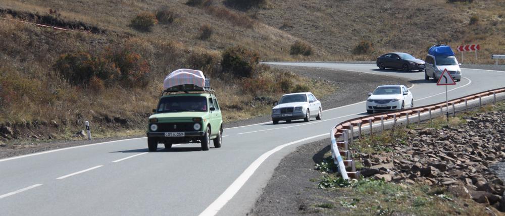 Vollbepackte Autos mit Sachen von Flüchtlingen aus Bergkarabach sind in den Serpentinen des Südkaukasus gen Armenien unterwegs.