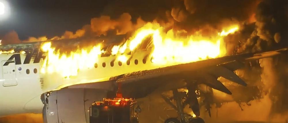 Dieses Videostandbild zeigt ein Passagierflugzeug, das bei der Landung auf dem Tokioter Flughafen Haneda in Brand geraten ist.