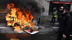  Ein Demonstrant geht während einer Kundgebung gegen das Gesetz zur Reform des Rentensystems in Rennes an brennenden Trümmern vorbei.