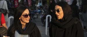 Frauen spazieren im Geschäftsviertel Teherans, ohne ihr islamisches Kopftuch zu tragen. 
