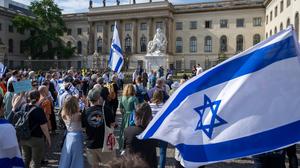 Teilnehmer stehen mit israelischen Fahnen bei einer Kundgebung von Fridays for Israel vor der Humboldt-Universität.