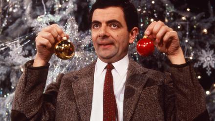 Mr. Bean (Rowan Atkinson) vor einem Weihnachtsbaum.