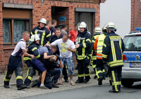 Drei Männer behindern am 05.07.2015 in Bremervörde (Niedersachsen) nach einem tödlichen Unfall die Arbeit der Rettungskräfte.