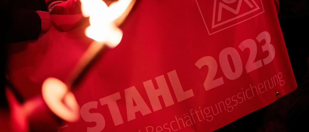 Ein Demonstrant hält in Duisburg ein Banner mit der Aufschrift «Stahl 2023» während eines Protests im Zuge des Tarifstreits. Die IG Metall hat im Tarifkonflikt der nordwestdeutschen und ostdeutschen Stahlindustrie nach der vierten Verhandlungsrunde ohne Ergebnis ganztägige Warnstreiks angekündigt.
