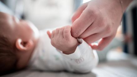 Ein Baby klammert sich an den Finger seiner Mutter. (Symbolbild)