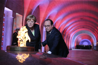 Der französische Präsident Francois Hollande und Bundeskanzlerin Angela Merkel entzünden gemeinsam die Flamme in der Nationalnekropole Douaumont bei Verdun.