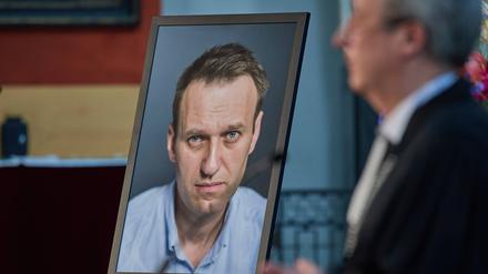 Landesbischof Christian Stäblein spricht neben einem Bild von Alexej Nawalny. 