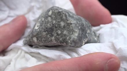 Ein mutmaßliches Meteoritenteil liegt in einem Papiertaschentuch. 