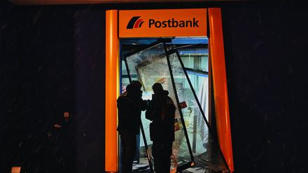 Polizisten stehen im zerstörten Eingangsbereich einer Bank im Märkischen Viertel. 