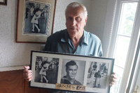 George Mendonsa lässt sich mit alten Fotos von sich fotografieren, u.a. einer Kopie (l) des berühmten Alfred Eisenstadt-Fotos "Küssender Matrose". (Archivbild 2009)