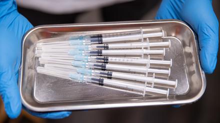 Aufgezogene Spritzen mit Impfstoff gegen Covid-19 liegen in einer Schale. Das Düsseldorfer Landgericht verhandelt an diesem Donnerstag (10.00) über mehrere Klagen wegen angeblicher Schäden durch die Corona-Schutzimpfungen mit Wirkstoffen der Hersteller Biontech und Moderna.