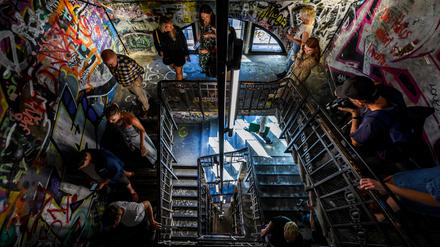 Visitors walk down a stairwell decorated with graffiti during a press preview at the Fotografiska photography museum, housed in the former art squat "Kunsthaus Tacheles" in Berlin on September 7, 2023. The Fotografiska museum will open its doors to the public on September 14, 2023. (Photo by John MACDOUGALL / AFP)