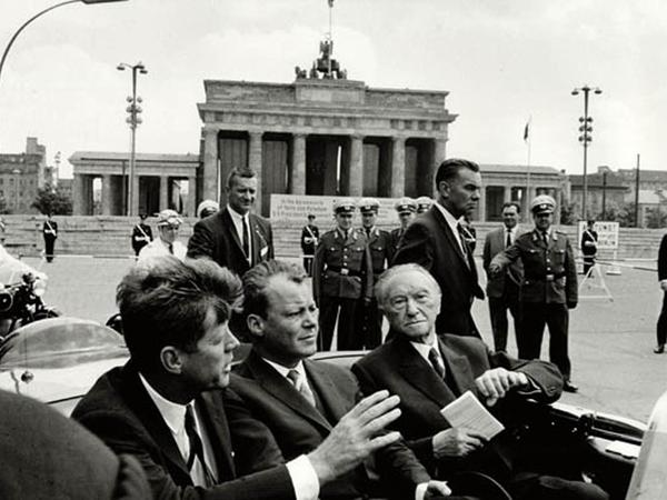 John F. Kennedy, Willy Brandt und Konrad Adenauer vor dem verhangenen Brandenburger Tor ... 