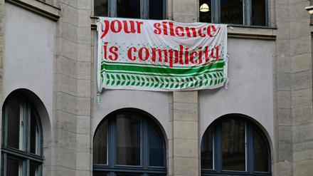 Ein Banner mit der Aufschrift „Your silence is complicity“ hängt am besetzten Institut für Sozialforschung der Humboldt-Universität.