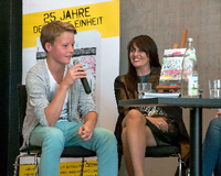 Schüler August Rohr (LIN Berlin) bei der Buchpräsentation. Im Hintergrund: Birgit Murke, Herausgeberin von "Geteilte Ansichten".