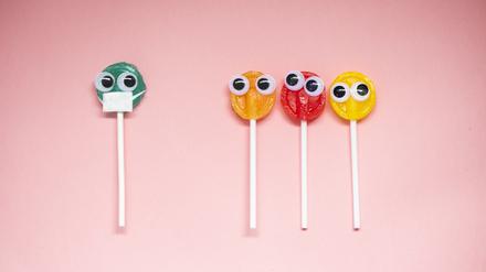Lollipop with Cartoon Eyes on Pink Colored Background, social distancing and coronavirus concept.