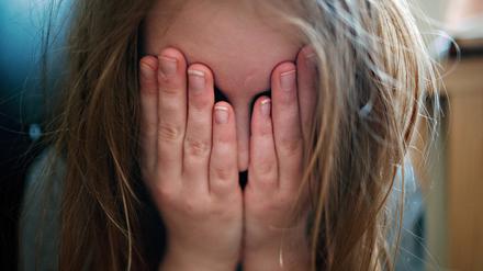 Ein junges Mädchen hält sich die Hände vor ihr Gesicht. Eine Gruppe von Kindern und Jugendlichen soll eine Mitschülerin misshandelt haben. (Symbolfoto)