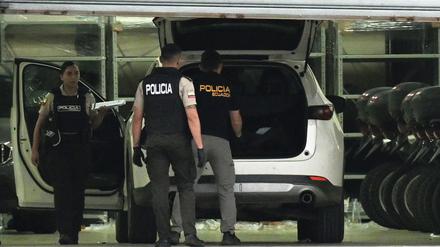 Polizisten in Schutzwesten untersuchen das Auto des erschossenen Staatsanwalts César Suárez in Guayaquil.