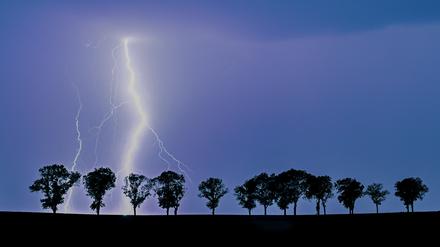 Ein Blitz eines Gewitters erhellt den Nachthimmel. (Symbolbild)