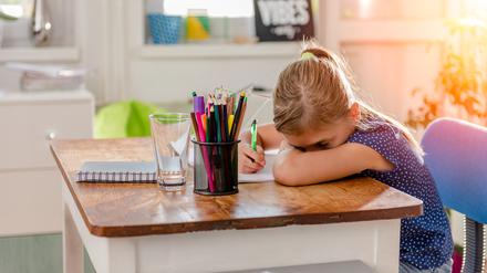 Girl in blue shirt having problem with concentration to finish home work
