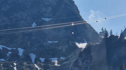 Ein Gleitschirmflieger hängt in den Seilen einer Seilbahn in Oberbayern. Der Mann hatte sich an der höchsten Stelle der Hochfelln-Seilbahn in Bergen im Chiemgau rund 80 Meter über dem Boden mit seinem Fluggerät in den Stahlseilen verfangen.