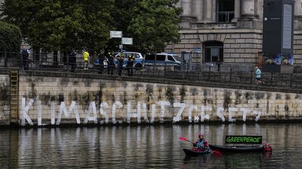 Aktivisten der Umweltschutz-Organisation Greenpeace haben auf der Kaimauer unterhalb des Reichstages das Wort „Klimaschutzgesetz“ geschrieben. 