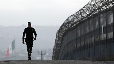 Der US-Grenzpolizist Eduardo Olmos läuft am 22.06.2016 entlang des Zauns an der Grenze zwischen USA und Mexiko in San Diego (USA).