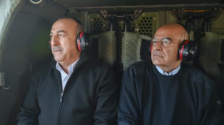 Der griechische Außenminister Nikos Dendias (rechts) und sein türkischer Amtskollege Mevlut Cavusoglu überfliegen erdbebengeschädigten Gebiete der Türkei.