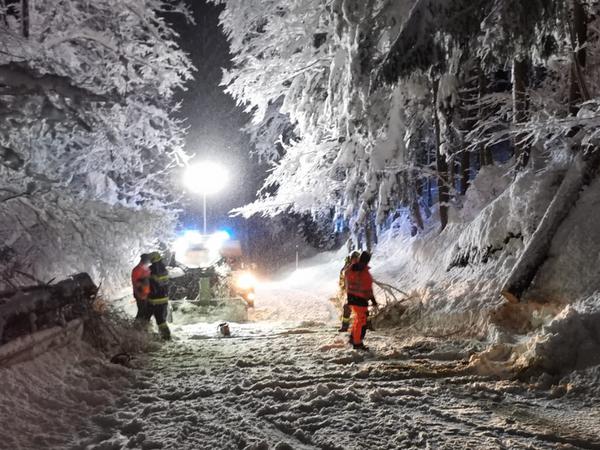A firefighter and helpers are on duty in Austria after heavy snowfall. 