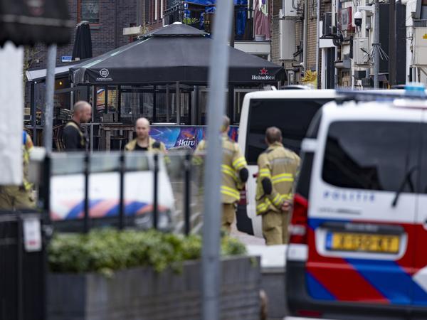 Polizisten und Feuerwehrleute stehen in der Nähe des Tatorts (Hintergrund). Die Geiselnahme in einem Café dauerte mehrere Stunden.