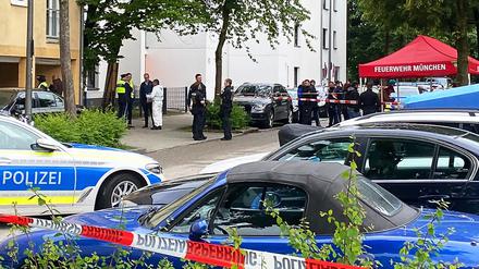 Einsatzkräfte der Polizei stehen vor einem Mehrfamilienhaus im Stadtteil Milbertshofen. 