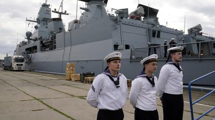 Besatzungsmitglieder der deutschen Fregatte Hamburg stehen vor dem Schiff in Riga. 