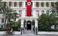 Eine Hakenkreuz-Fahne und die Wehrmacht vor dem Sitz der Präfektur in Nizza.