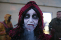 Eine Frau, verkleidet als professioneller Erschrecker für das Halloween Horror Fest, raucht eine Zigarette im Movie Park Germany in Bottrop.