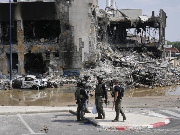 08.10.2023, Israel, Sderot: Israelische Polizisten stehen vor einer zerstörten Polizeistation.