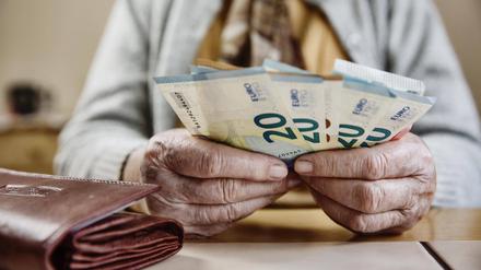Eine Seniorin zählt ihr Geld.
