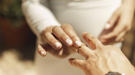 Ein Ring wird auf den Finger gesteckt – nun ist das Paar symbolisch verbunden.