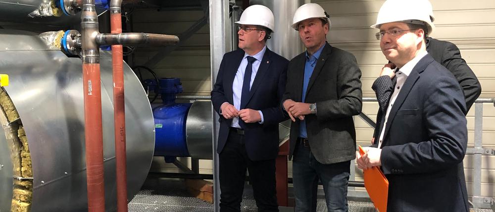 Infrastrukturminister Rainer Genilke (CDU, l.) besichtigt ein Projekt zum klimafreundlichen Heizen in Brandenburg/Havel.