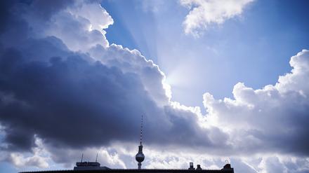 Die Sonnenstrahlen kommen hinter einer dunklen Wolke über dem Fernsehturm hervor. (Symbolfoto)