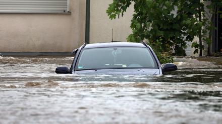 02.06.2024, Bayern, Offingen: Ein Auto steht im Hochwasser der Mindel in einem Wohngebiet.