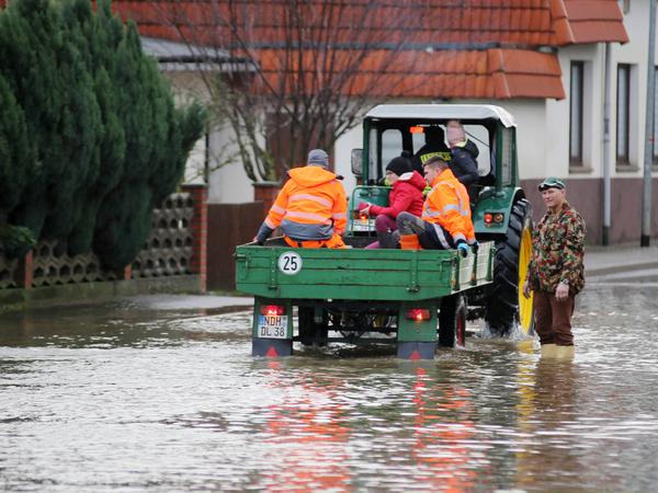 Ein Traktor fährt durch die überflutete Ortschaft Windehausen in Thüringen. 
