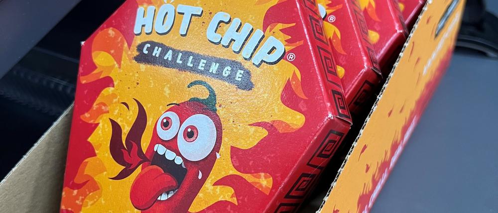 Mehrerer Packungen der „Hot Chip Challenge“ liegen bei einem Kiosk neben der Kasse.