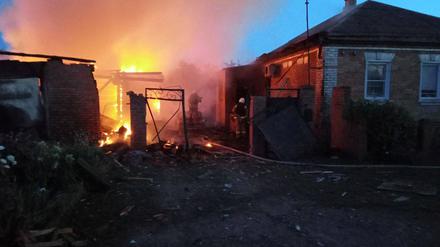 Feuerwehrleute versuchen am 2. Juni den Brand an einem Haus im Dorf Sobolevka in der Region Belgorod zu löschen.