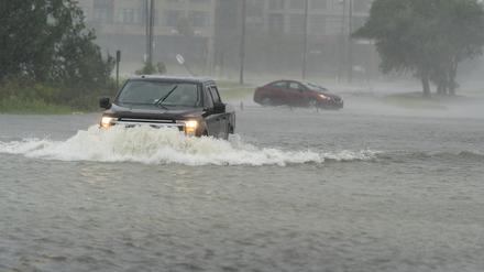 30.09.2022, USA, Charleston: Ein Autofahrer fährt durch Hochwasser, das durch Hurrikan Ian verursacht wurde. Foto: Alex Brandon/AP/dpa +++ dpa-Bildfunk +++