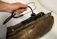 Ein Landarzt nimmt sein Stethoskop aus dem Koffer.