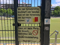 Schilder an Berliner Fußballplatz, die zu Gewaltlosigkeit und Respekt aufrufen.