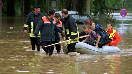 Feuerwehrmänner bergen Dresdner Einwohner im Schlauchboot aus der überschwemmten Stadt.